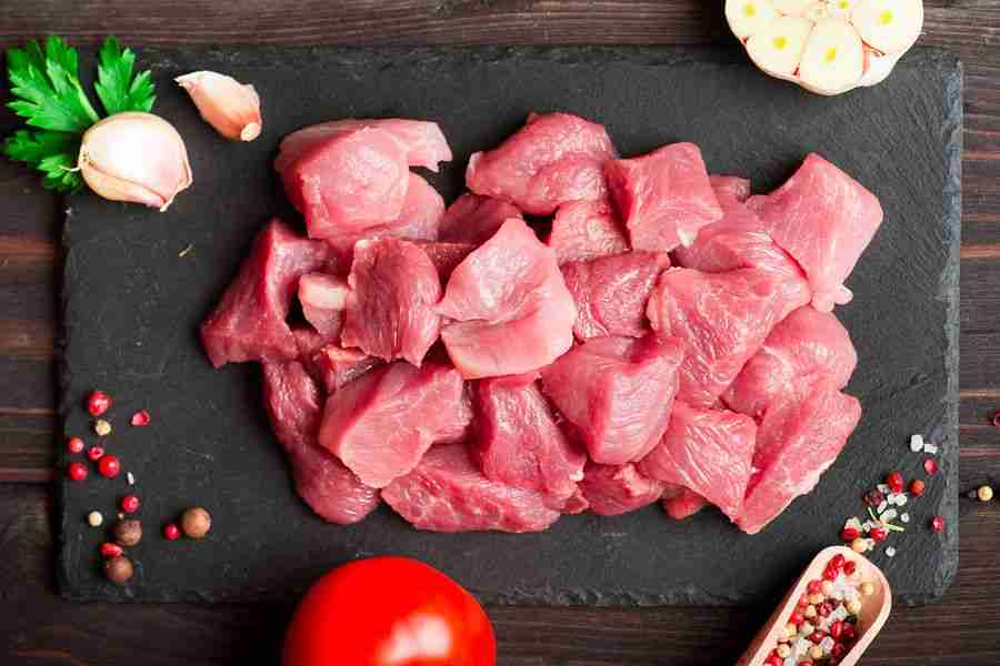 Raw chopped fresh meat with pepper and herbs over dark stone cut